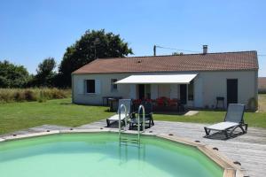 a swimming pool in front of a house at Le HAMEAU 1936 Gîte des Milanaïs in Cherveux