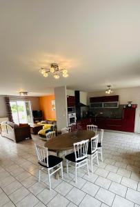 a dining room and living room with a table and chairs at Le HAMEAU 1936 Gîte des Milanaïs in Cherveux +18 photos