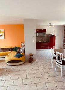 ein Wohnzimmer mit Sofa und Tisch in der Unterkunft Le HAMEAU 1936 Gîte des Milanaïs in Cherveux