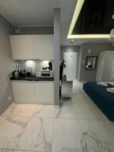 a kitchen and a bedroom with a bed and a counter at Apartamenty Prestiż Podfigórna 200 metrów od centrum in Koszalin
