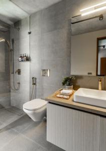 ein Badezimmer mit Toilette, Waschbecken und Dusche in der Unterkunft LohonoStays Amani Villa 9B in Coonoor