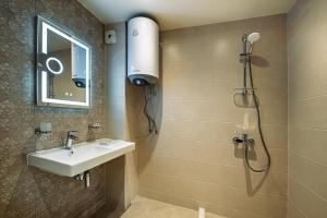 a bathroom with a sink and a shower at Cityscape Luxury Suites in Plovdiv +81 photos