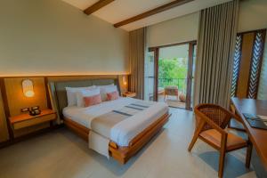a bedroom with a large bed and a desk and a desk at Cebu Beach Club in Argao