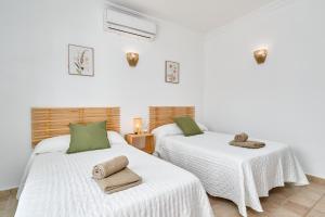 2 posti letto in una camera bianca con asciugamani di Villa Grayce a Frigiliana Altre 21 foto