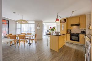 a kitchen and dining room with a table and chairs at Luxury Ocean View Beachfront 2 bed apartment -206 The Waves, Blouberg, Cape Town in Bloubergstrand