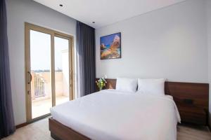 een slaapkamer met een wit bed en een groot raam bij Toàn Cầu Villa in Dương Cảnh