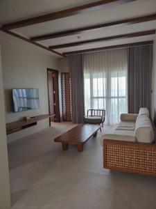 a living room with a couch and a tv at Cebu Beach Club in Argao
