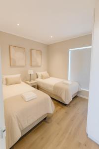 a bedroom with two beds and a window at Beachfront Luxury Apartment Sea View & Free Parking in Gqeberha
