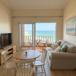 a living room with a couch and a table at Beachfront Luxury Apartment Sea View & Free Parking in Gqeberha