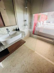 ein Badezimmer mit Waschbecken und Bett in der Unterkunft Minh Tân Apartment Mandala in Mui Ne
