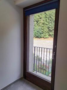 a glass door with a view of a balcony at Casa da Normi in Valdisotto