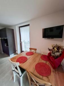 tavolo da pranzo con piatti rossi di Casa da Normi a Valdisotto