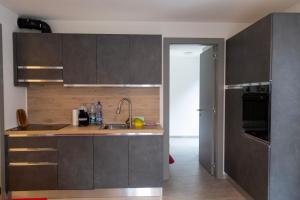 una cucina con mobili grigi e un lavandino di Casa da Normi a Valdisotto Altre 20 foto