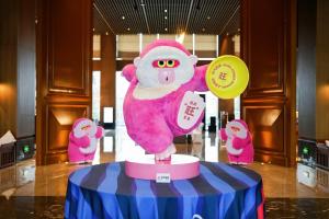 a statue of a monkey holding a frisbee on a table at Le Meridien Emei Mountain Resort in Emeishan
