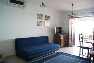 a living room with a blue couch and a table at Apartmani Braco Caratan in Zavala