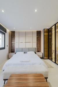 1 dormitorio con 1 cama blanca grande y puertas de cristal en Studio sky lux 94, en Tánger