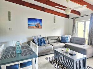 a living room with a couch and a table at Chakas Rock Chalet 45 in Ballito