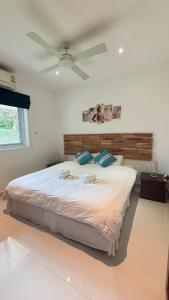 a bedroom with a large bed with a ceiling fan at Villa Sun 4 in Mae Nam