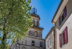 a clock tower on top of a building at Spacieux Duplex - Lumineux et Calme - Alpilles in Eyguières