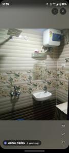 baño con lavabo y teléfono en la pared en Hotel bodhi Inn, en Lucknow