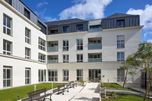 un edificio con bancos delante en Quality Suites Saumur, en Saumur