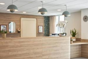 Una peluquería con espejo y lámparas colgantes en Quality Suites Saumur, en Saumur