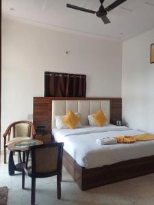 een slaapkamer met een bed, een stoel en een tafel bij The JRS Hotel in Rishīkesh