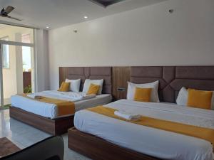 2 bedden in een hotelkamer met 2 slaapkamers bij The JRS Hotel in Rishīkesh