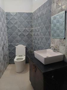 een badkamer met een wit toilet en een wastafel bij The JRS Hotel in Rishīkesh