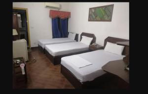 een hotelkamer met drie bedden in een kamer bij Khan Regency Hotel in Dargai