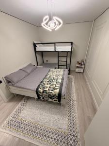 a bedroom with a bed and a rug and a chandelier at NovaMotel in Karakol