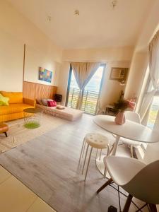 Una sala de estar con un sofá amarillo y una mesa. en Semi Furnished Condo at Sta Rosa Zadia Tower 2, en Sampong