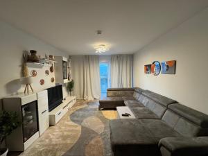 ein Wohnzimmer mit Sofa und Fernseher in der Unterkunft Home Away From Home in Schönefeld