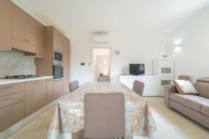 a kitchen and living room with a table and a couch at Brorent A & L apartment B in Golfo Aranci