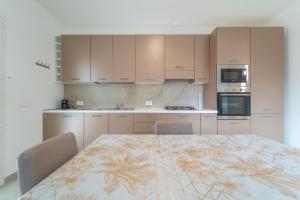 a kitchen with a table and chairs and appliances at Brorent A & L apartment B in Golfo Aranci