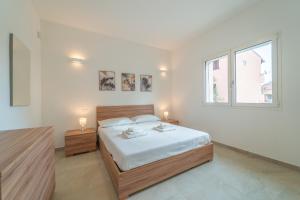 a bedroom with a large bed with two lamps on it at Brorent A & L apartment B in Golfo Aranci