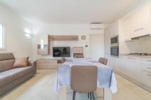 a kitchen and living room with a table and a couch at Brorent A & L apartment T in Golfo Aranci