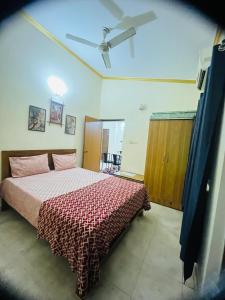 a bedroom with a bed with a red comforter at Tropical VIBES RETREAT in Calangute