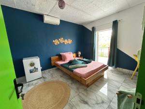 PamandziにあるSteilaDay Hébergement 976の青い壁のベッドルーム1室(ベッド1台付)