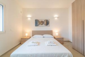 a bedroom with a large bed with two towels on it at Brorent A & L apartment T in Golfo Aranci