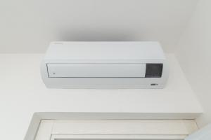 a white microwave hanging from a white wall at Brorent A & L apartment T in Golfo Aranci