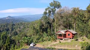 a small red house on a hill next to a road at เดอะ เคบิน อินทนนท์ - The Cabin Inthanon in Ban Yang +9 photos