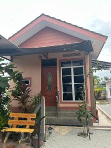 een klein huis met een rode deur en een bank bij DGarden Homestay in Kuala Terengganu +4 foto's