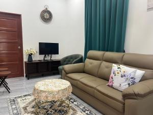 een woonkamer met een bank en een tafel bij DGarden Homestay in Kuala Terengganu