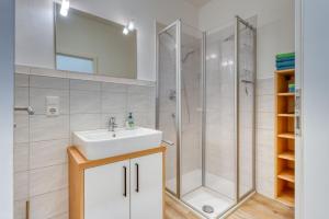 a bathroom with a sink and a shower at Alte Teestube Schmidt 59 Rechts in Norderney +9 photos