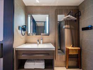 een badkamer met een wastafel en een douche bij Hanting Hotel Chengdu Tianfu Square Subway Station in Chengdu