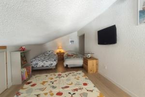 una camera da letto con due letti e una TV a schermo piatto di Les Eterlous N44 2P6 a Morillon