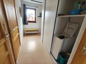 un corridoio con una porta aperta su una cucina con un frigorifero di Les Eterlous N44 2P6 a Morillon