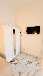 Ein Zimmer mit Marmorboden und einem Fernseher an der Wand. in der Unterkunft torres family locazione turistica in Foggia