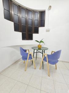 a table and chairs with a potted plant on it at Warni Villa 8 Whole Or Room in Muar